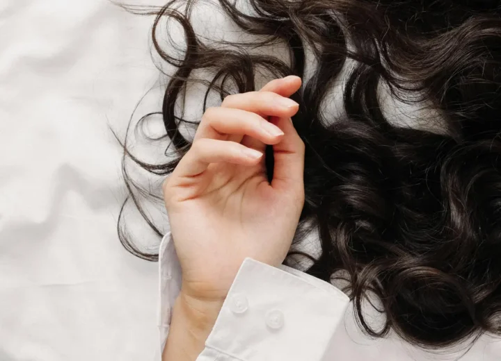 Kobieta z naturalnie falującymi lokami stworzonymi metodą beztlenową bez użycia lokówki